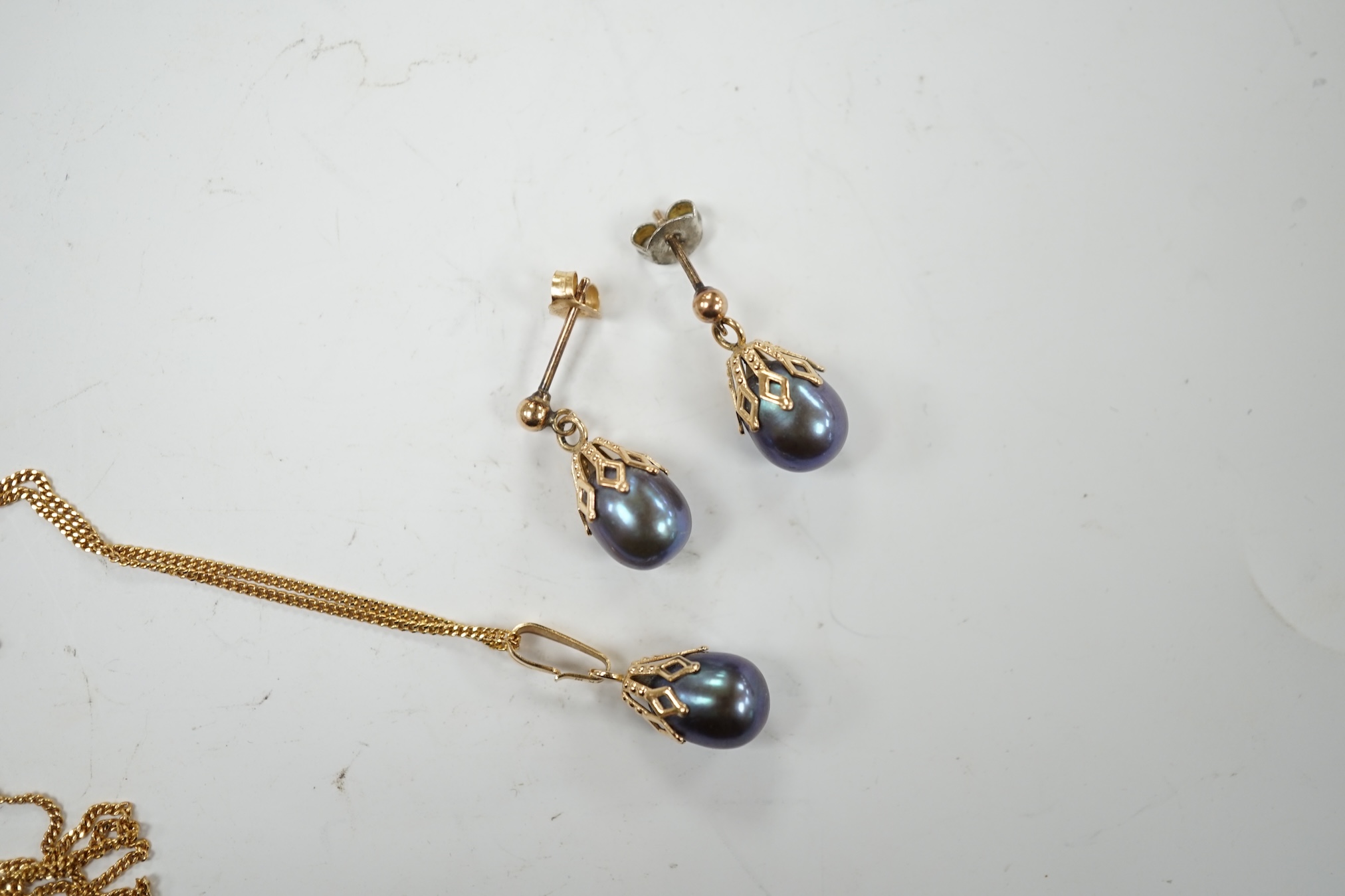 A 14k and Tahitian cultured pearl set pendant, 22mm, on an Italian Uno-A-Erre 9ct gold chain, 46cm, together with a pair of similar pair of yellow metal and Tahitian cultured pearl set ear studs, gross weight 5.1 grams.